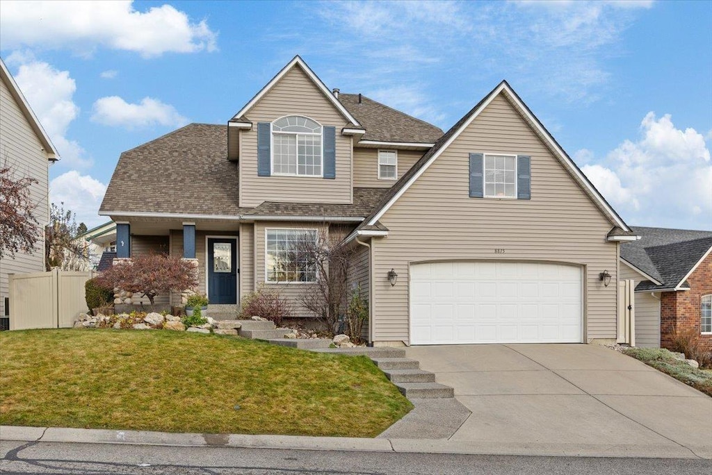 view of property with a garage and a front lawn