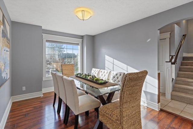 dining room with dark hardwood / wood-style flooring and a textured ceiling