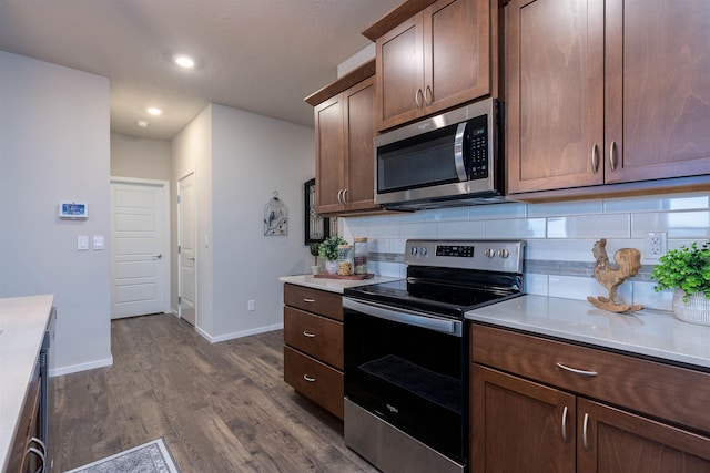 kitchen featuring decorative backsplash, dark wood-type flooring, and stainless steel appliances