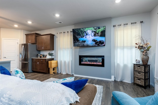 interior space featuring stainless steel fridge with ice dispenser and dark wood-type flooring