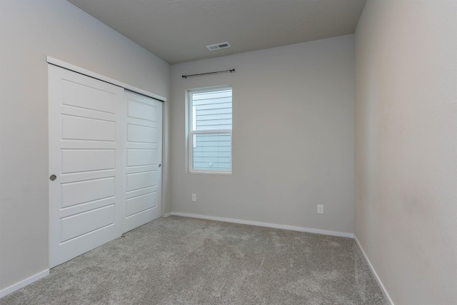 unfurnished bedroom with light carpet and a closet