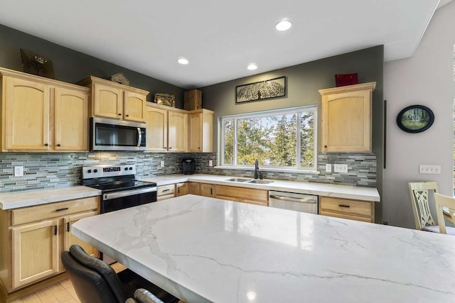12507 N Cherokee Dr, Newman Lake, WA 99025 - kitchen with stainless steel appliances, light brown cabinets, a sink, light stone countertops, and backsplash