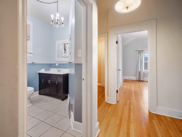 hallway featuring a chandelier, light hardwood / wood-style flooring, and sink