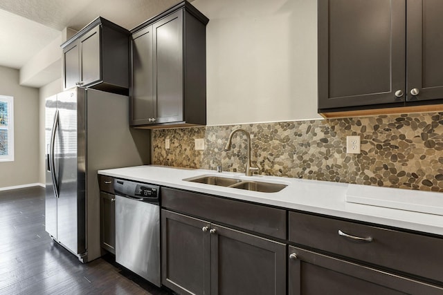 kitchen with backsplash, dark wood-type flooring, sink, stainless steel dishwasher, and dark brown cabinetry