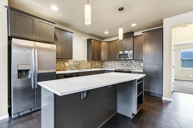 kitchen featuring decorative light fixtures, a kitchen island, dark brown cabinetry, and stainless steel appliances