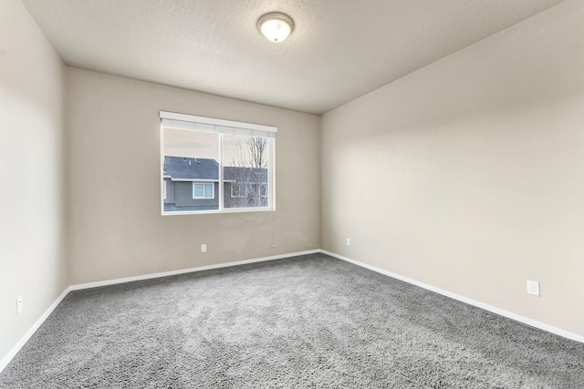 carpeted empty room featuring a textured ceiling