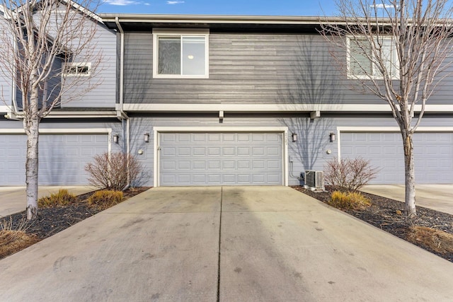 view of front property with a garage and central AC