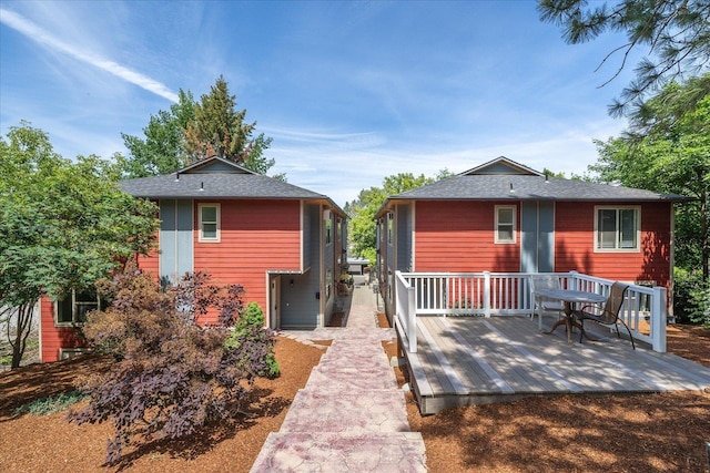 rear view of house featuring a wooden deck