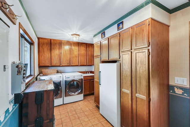 washroom featuring light tile patterned flooring, cabinets, separate washer and dryer, and sink