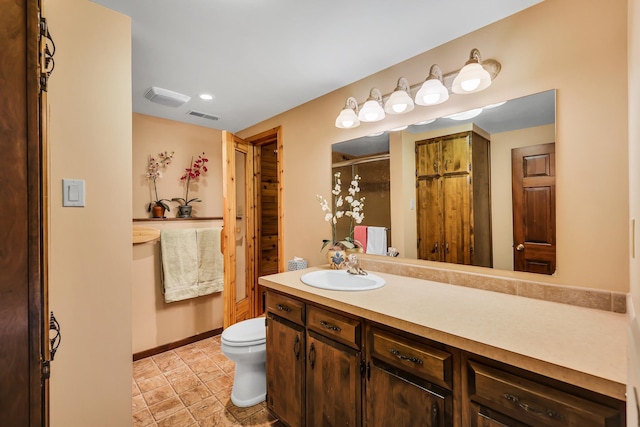 bathroom featuring vanity, toilet, and walk in shower