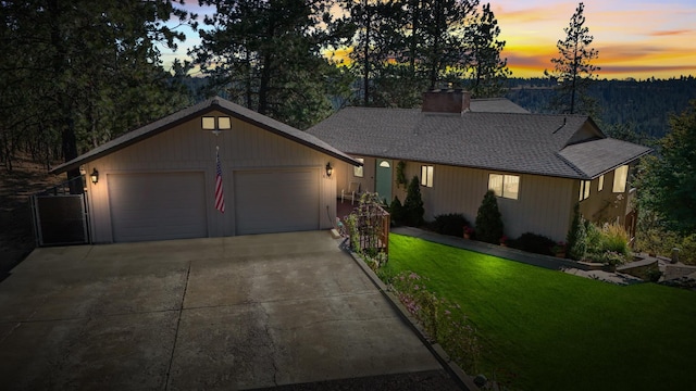 ranch-style house featuring a garage and a lawn