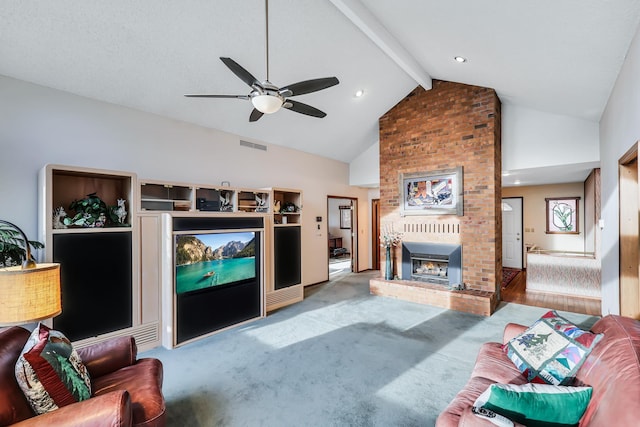 living room with vaulted ceiling with beams, ceiling fan, carpet floors, and a brick fireplace