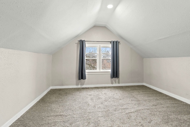 bonus room featuring carpet flooring, lofted ceiling, and a textured ceiling