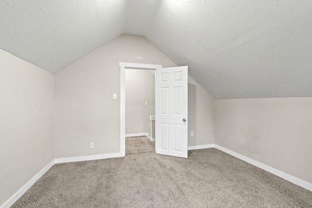 bonus room featuring a textured ceiling, carpet floors, and vaulted ceiling