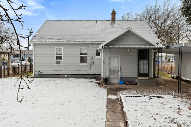 snow covered house with a carport