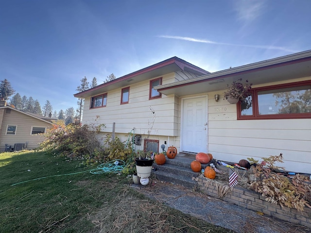 exterior space featuring central AC unit and a front yard