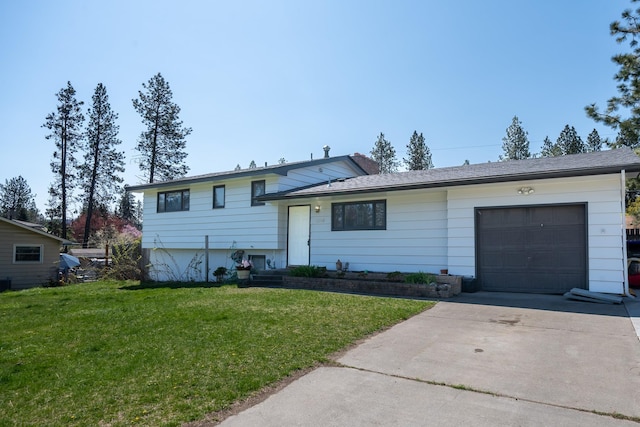 split level home featuring a garage, driveway, and a front lawn
