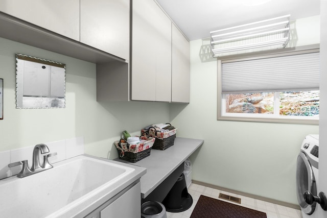 clothes washing area featuring cabinets, washer / dryer, and sink