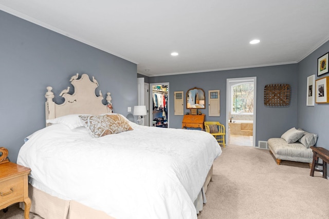 carpeted bedroom with a walk in closet, ensuite bathroom, a closet, and crown molding