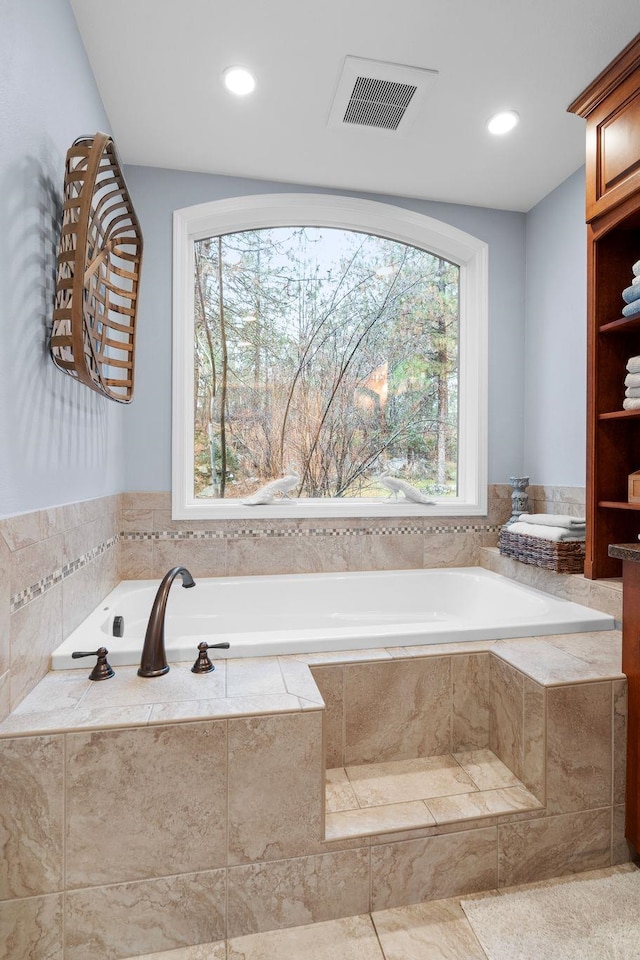 bathroom featuring tile patterned flooring and tiled bath