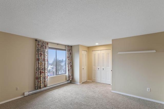 interior space with a textured ceiling and a baseboard heating unit