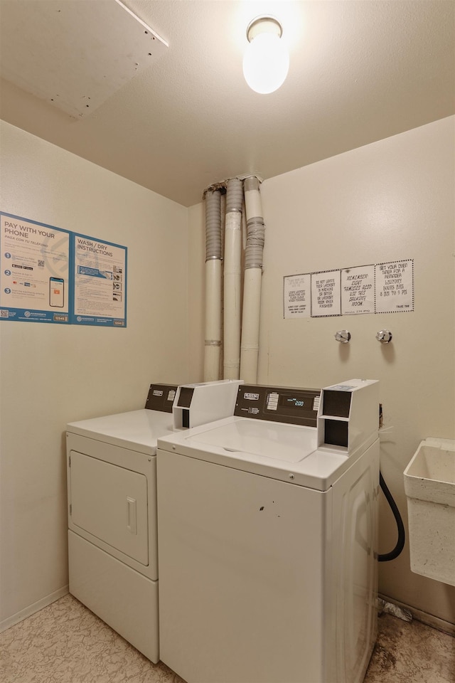 washroom with separate washer and dryer and sink