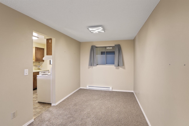 carpeted empty room featuring washer / dryer and baseboard heating