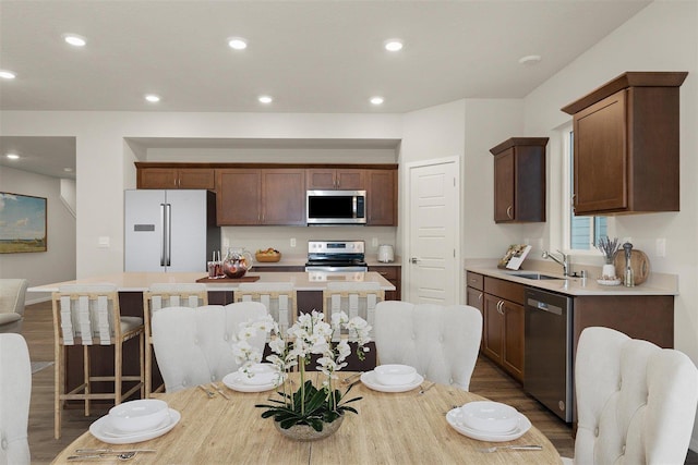 kitchen with a breakfast bar, sink, a kitchen island, and stainless steel appliances