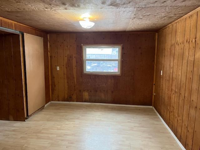 530 Kalmia St, Kettle Falls, WA 99141 - spare room featuring wooden walls, baseboards, and light wood-style floors