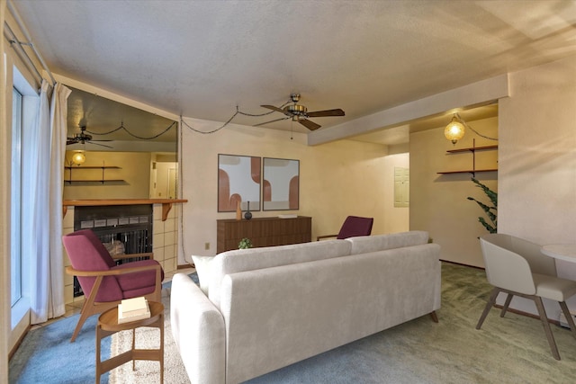 carpeted living room featuring ceiling fan and a textured ceiling