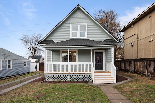 bungalow-style house featuring covered porch and a front yard