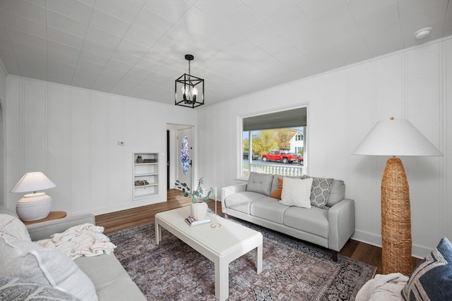 living room with dark hardwood / wood-style flooring and an inviting chandelier