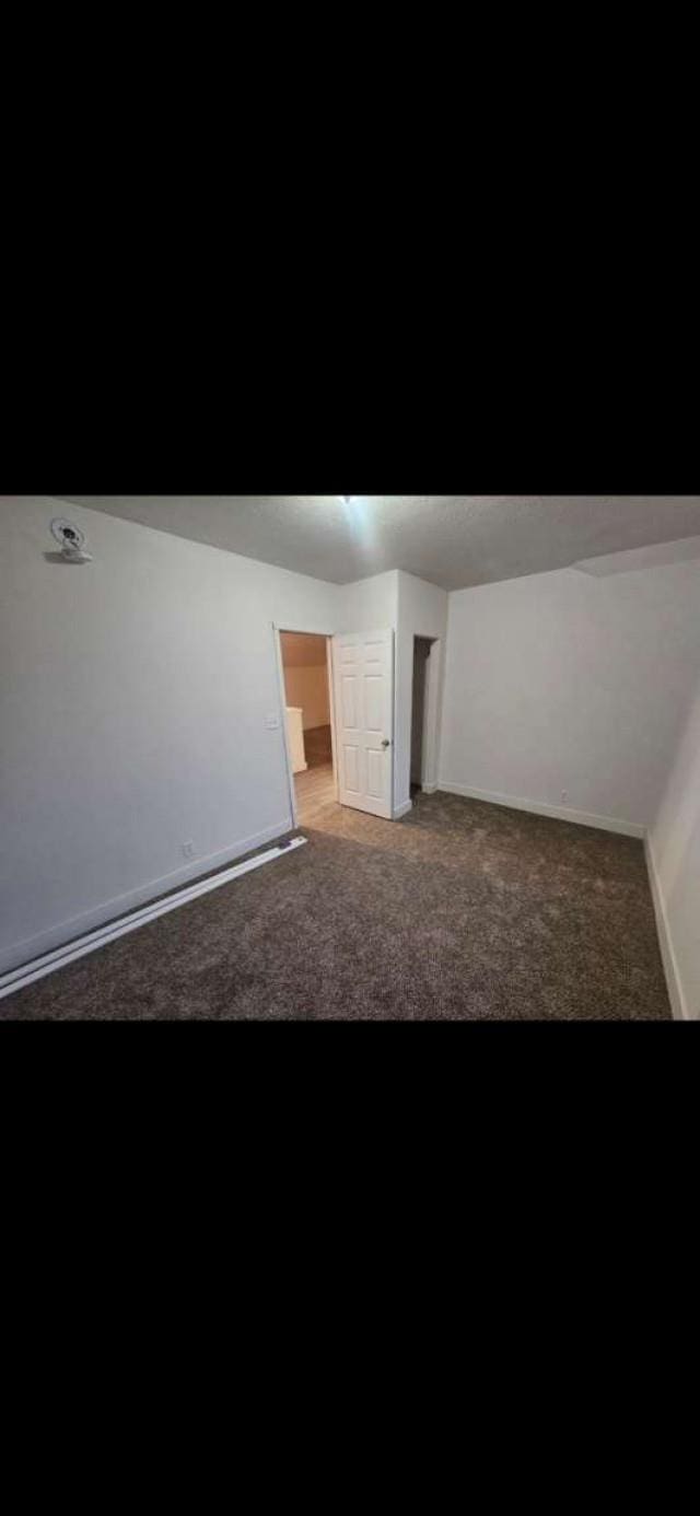 unfurnished room with dark carpet