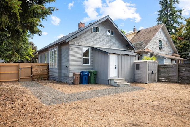 rear view of property featuring a storage unit