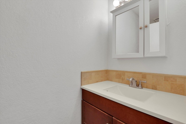 bathroom featuring vanity and backsplash