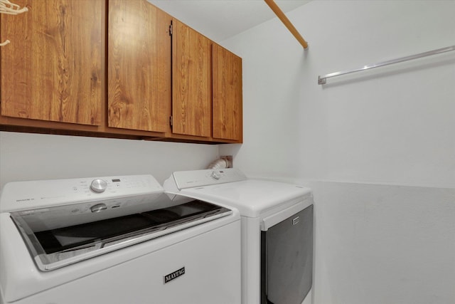 laundry room featuring washer and dryer and cabinets