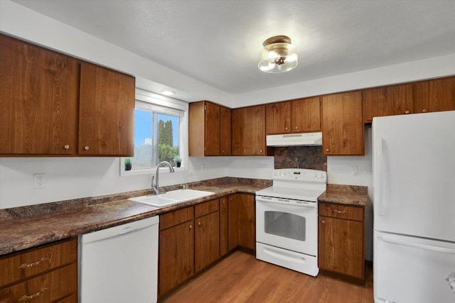 kitchen with sink, light hardwood / wood-style floors, and white appliances