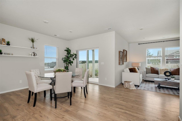 dining space with a wealth of natural light and light hardwood / wood-style flooring