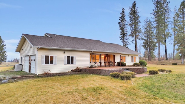 back of property featuring a porch, a garage, and a lawn