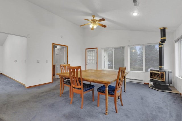 carpeted dining room with a wood stove, ceiling fan, high vaulted ceiling, and a baseboard radiator