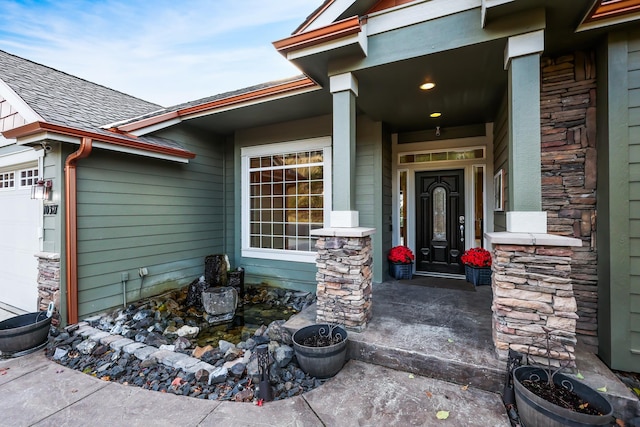 doorway to property with covered porch and a garage