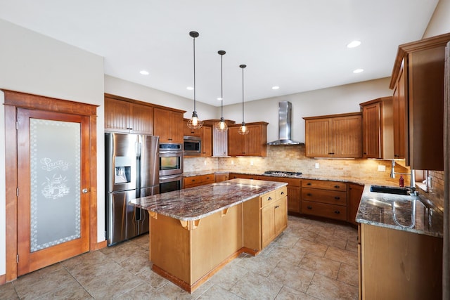 kitchen featuring appliances with stainless steel finishes, a kitchen island, dark stone countertops, and wall chimney range hood