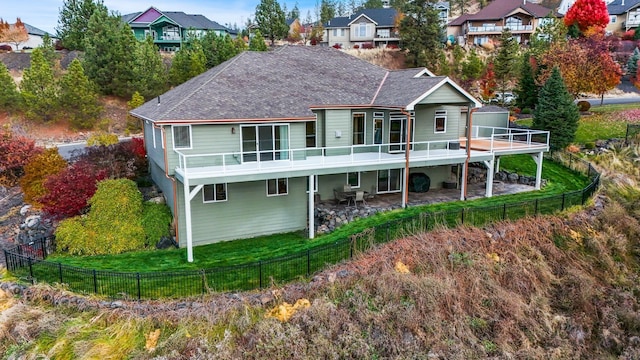 back of house featuring a deck, a yard, a patio, and a balcony