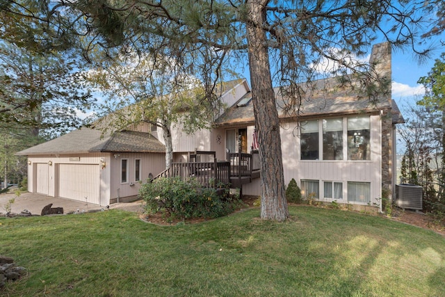 view of front of house with a wooden deck, central AC unit, a front yard, and a garage