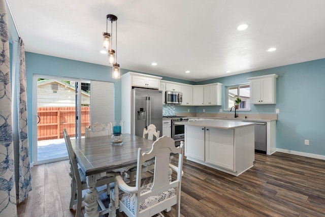 dining space with dark hardwood / wood-style floors, a wealth of natural light, and sink