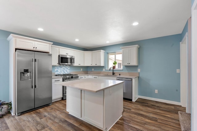 kitchen featuring white cabinets, a center island, high end appliances, and sink