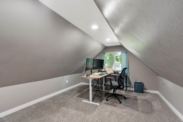 carpeted office featuring a textured ceiling and lofted ceiling