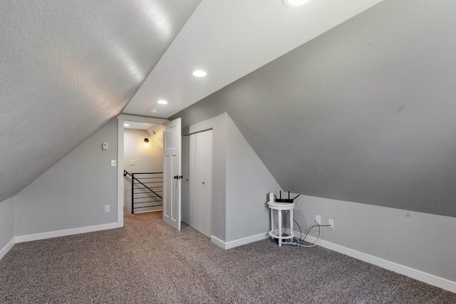 bonus room featuring a textured ceiling, carpet floors, and vaulted ceiling