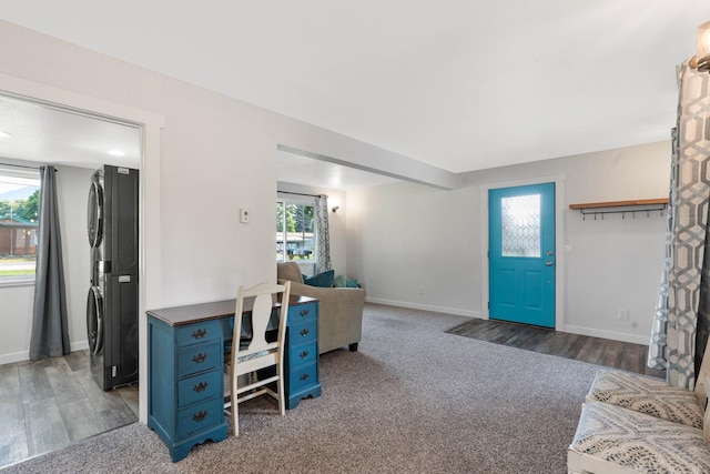 carpeted office featuring stacked washer and dryer