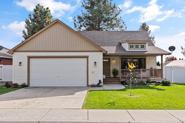 view of front of home featuring covered porch, a garage, and a front yard